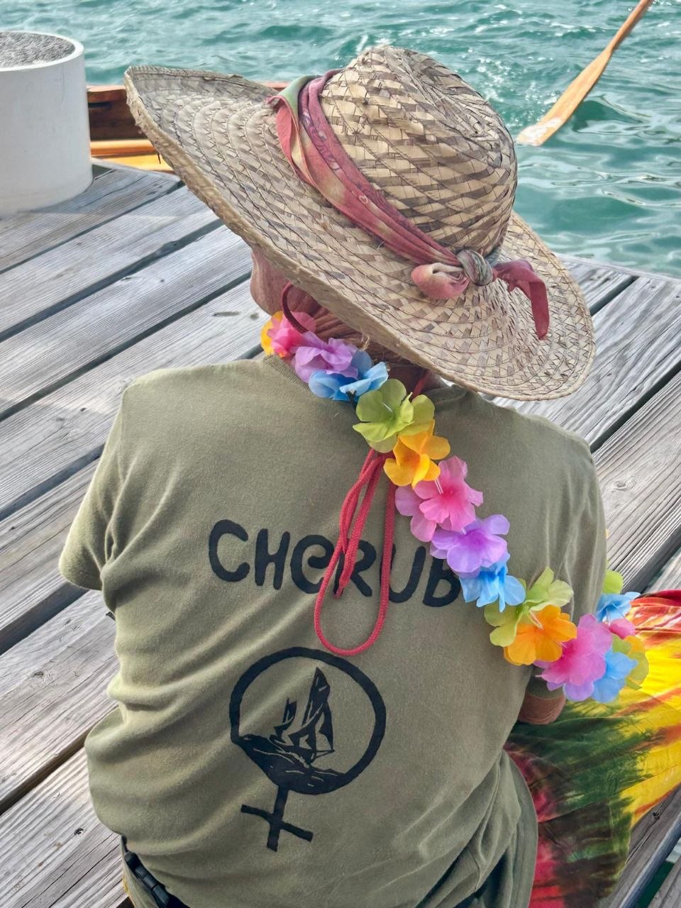 Cherub shirt and flower lei by the water