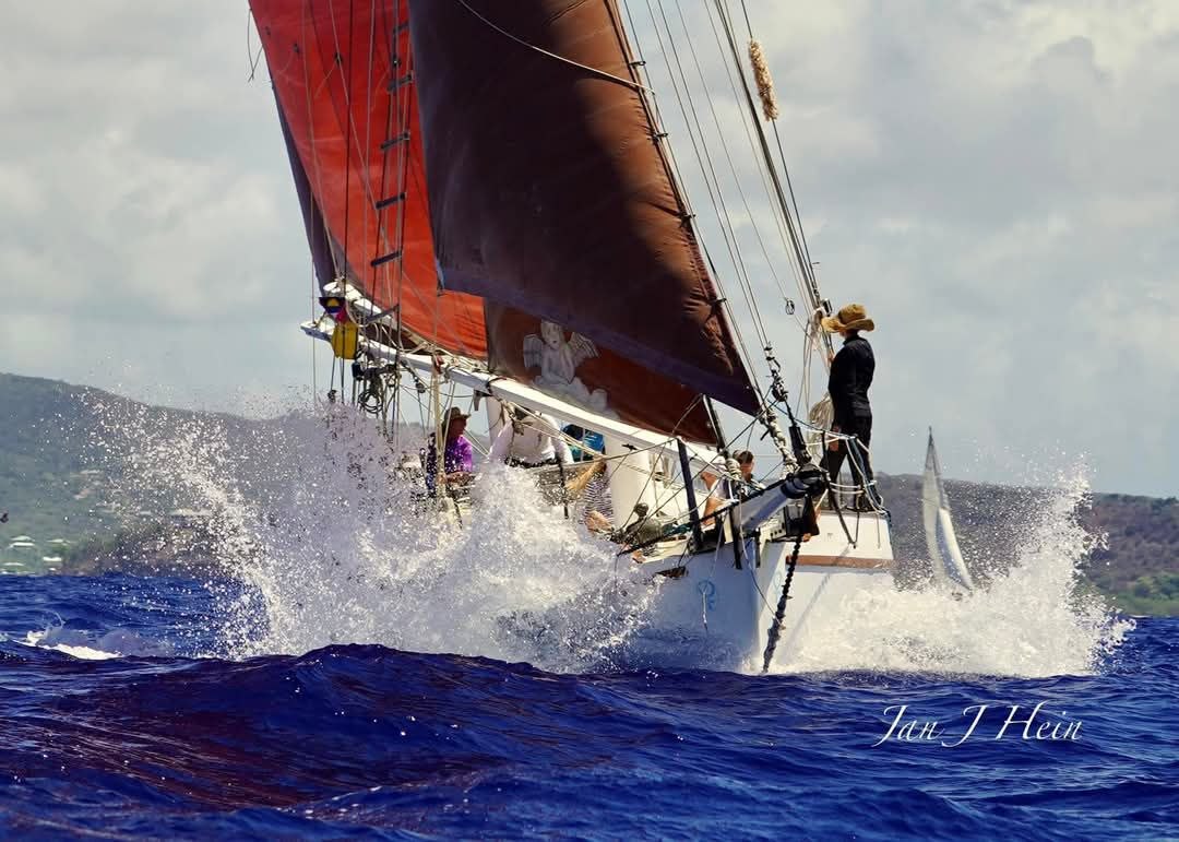 Cherub crashing through waves under tan sails, crew on deck
